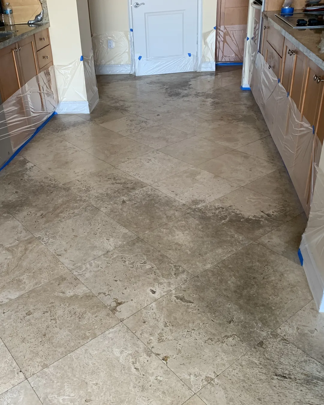 Stained travertine kitchen floor before restoration